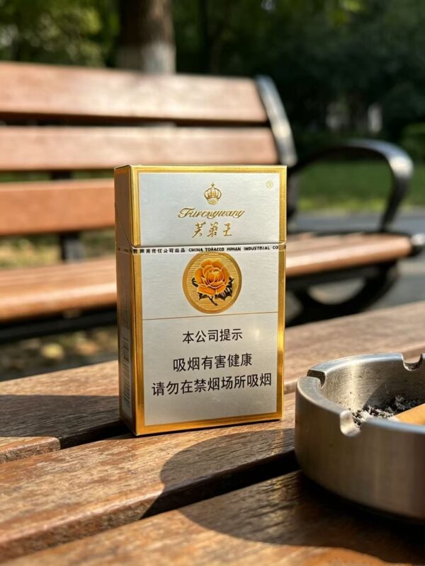 Furongwang White Pack Chinese cigarette pack on wooden table beside tea glass premium white and gold tobacco packaging